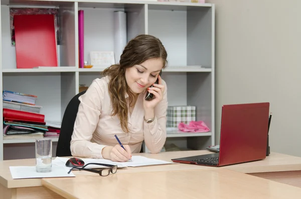 Business woman calling by phone and does records — Stock Photo, Image