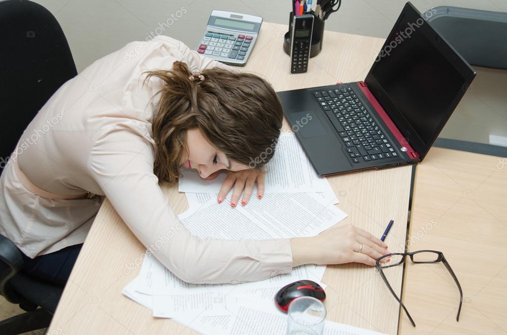 Tired woman asleep on a workplace at office