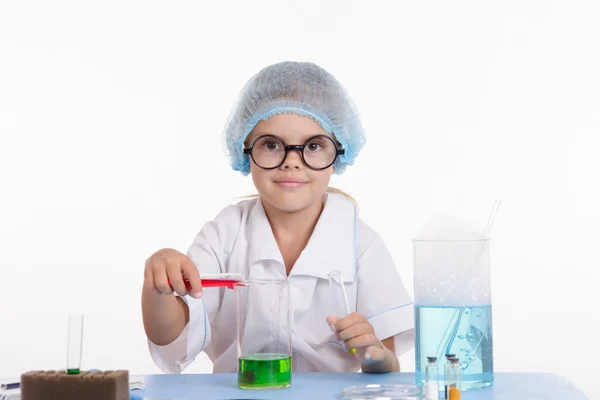 Trainee pouring liquid in a flask — Stock Photo, Image