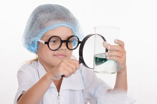 Kimyager coşku flask Büyüteç altında dikkate alınarak — Stok fotoğraf