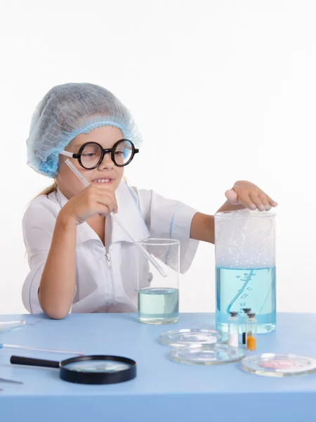 Chemist girl touches foam in flask — Stock Photo, Image