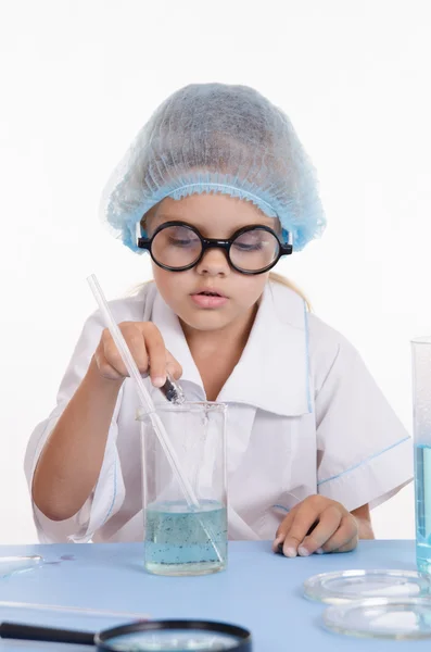 Girl chemist pours reagent into the flask with liquid — Stock Photo, Image