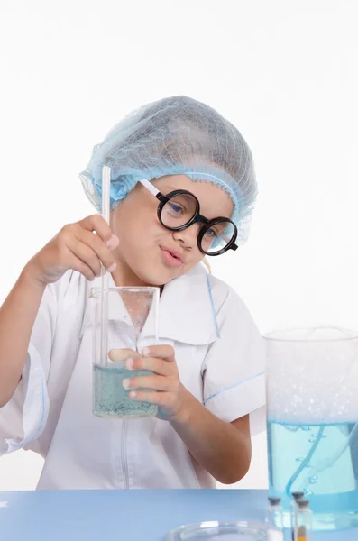 Girl chemist prevents the liquid in flask — Stock Photo, Image