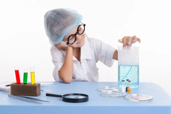 La chica química metió un dedo en agua jabonosa. — Foto de Stock