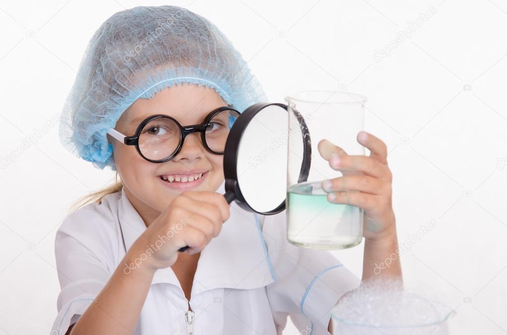 Chemist examines a flask under magnifying glass