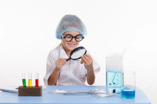 Chemiker schaut durch eine Lupe auf Pulver — Stockfoto
