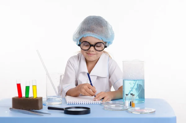 Químico escribiendo en un cuaderno los resultados experimentales —  Fotos de Stock