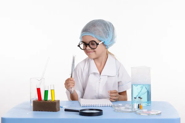 Girl chemist holding tweezers — Stock Photo, Image