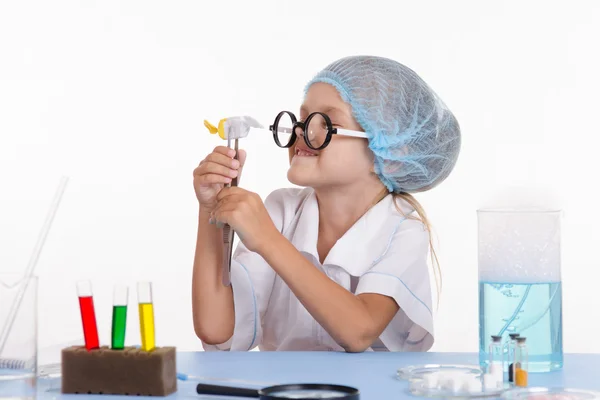 Girl holding in tweezers candy — Stock Photo, Image