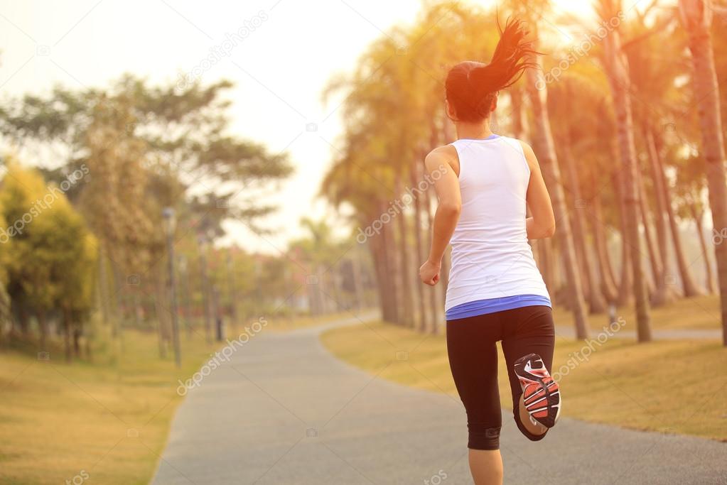 Asian woman jogging at tropical park