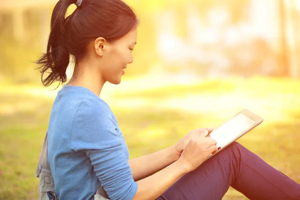 Student gebruik tablet pc zitten op gras — Stockfoto