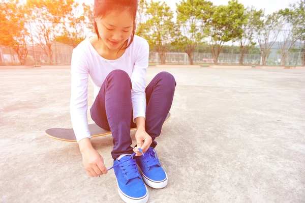 Young woman sit on skateboard — Stock Photo, Image