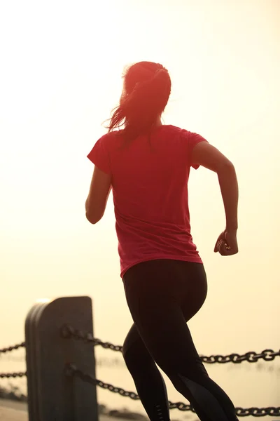 Kobieta joggingu na wschód słońca nad morzem — Zdjęcie stockowe