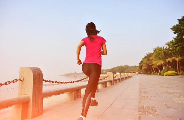 Woman jogging at sunrise seaside — Stock Photo, Image