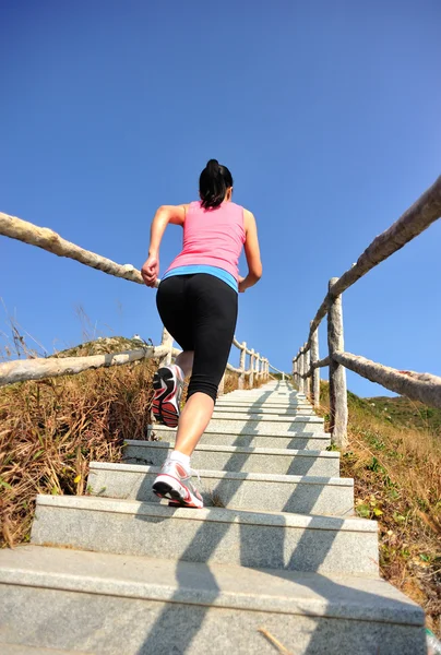 Femme courant sur les escaliers de montagne — Photo