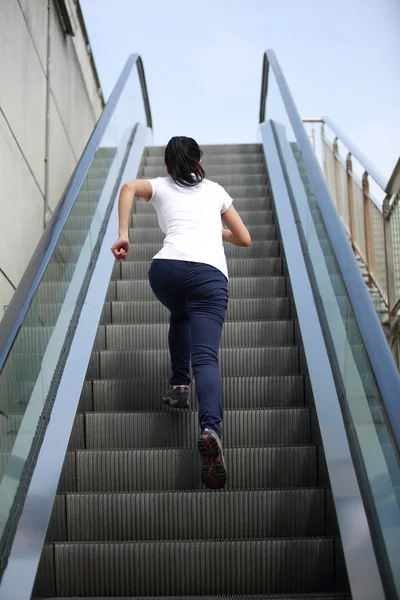 Mujer corriendo en escaleras mecánicas — Foto de Stock