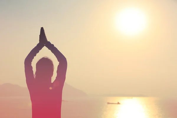 Mulher meditação ao nascer do sol à beira-mar — Fotografia de Stock