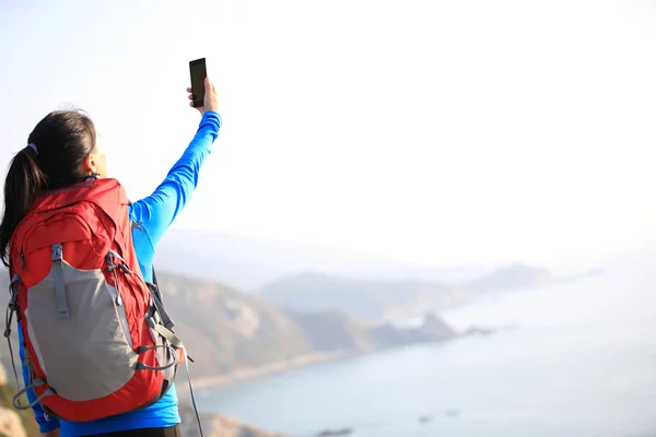 Mujer joven excursionista uso de teléfono inteligente — Foto de Stock