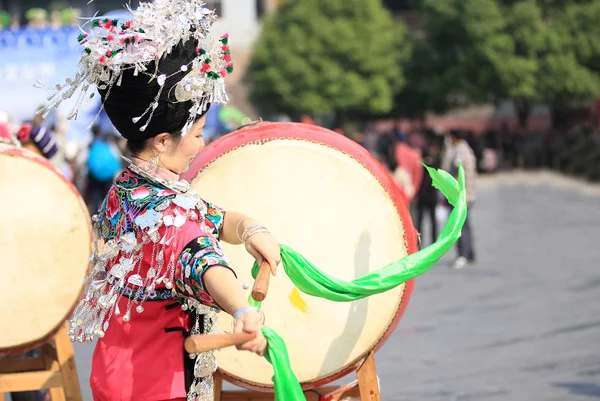Miao nationalité femme portant des accessoires en argent sur les cheveux et les vêtements bat un tambour — Photo