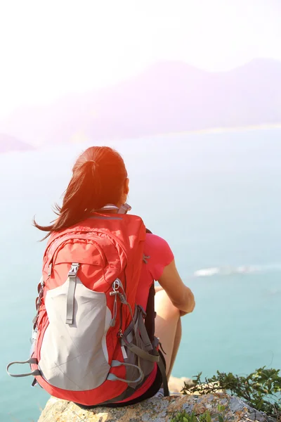 徒步旅行女人放松，坐在海边 — 图库照片