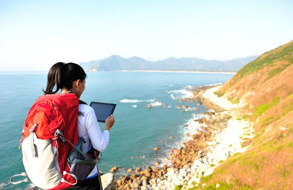 Woman on rock with digital tablet — Stock Photo, Image