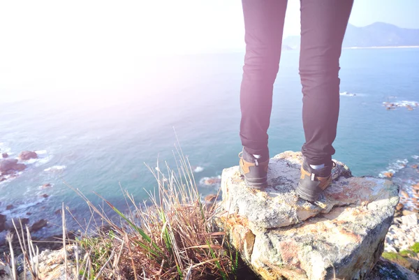 Hiking woman stand seaside mountain rock