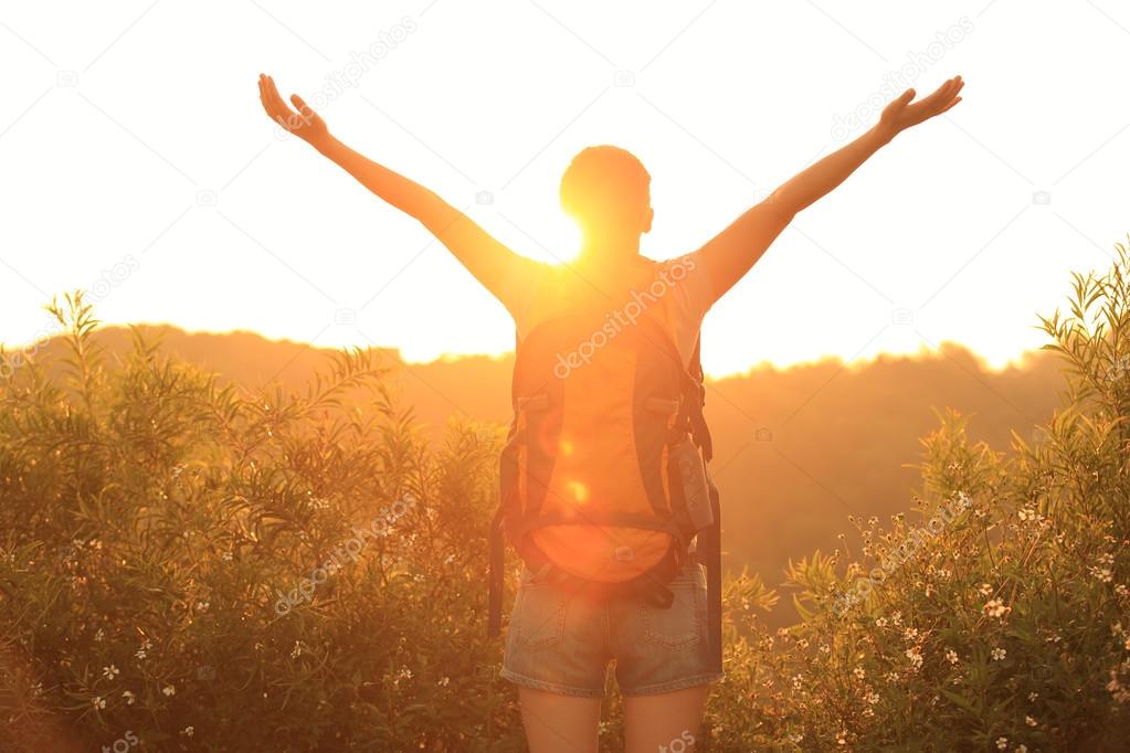 Thankful woman open arms to the sunrise