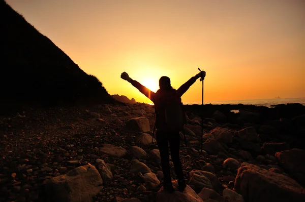 Благодарная женщина с распростертыми объятиями к восходу солнца — стоковое фото