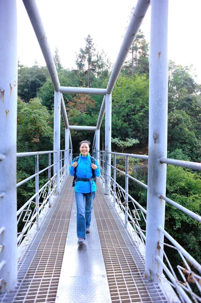 Woman hiker walking at bridge