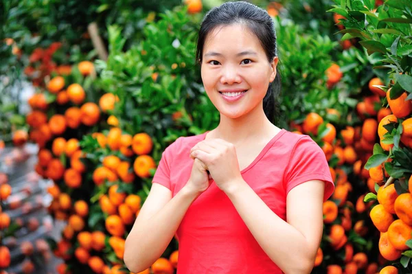 Jonge Aziatische in front de cumquat bomen — Stockfoto