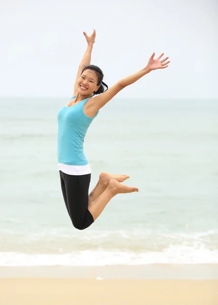 Счастливая женщина, прыгающая на пляже — стоковое фото