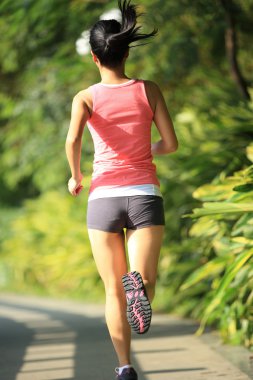 Parkta koşan Asyalı kadın.