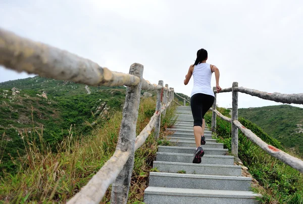 Woman running on mountain stairs — Stock Photo, Image