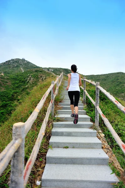 Femme courant sur les escaliers de montagne — Photo