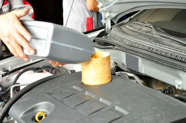 Mechanic pouring fresh oil to engine — Stock Photo, Image