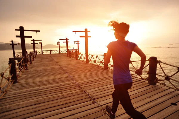 木造歩道海辺に走っている女性 — ストック写真