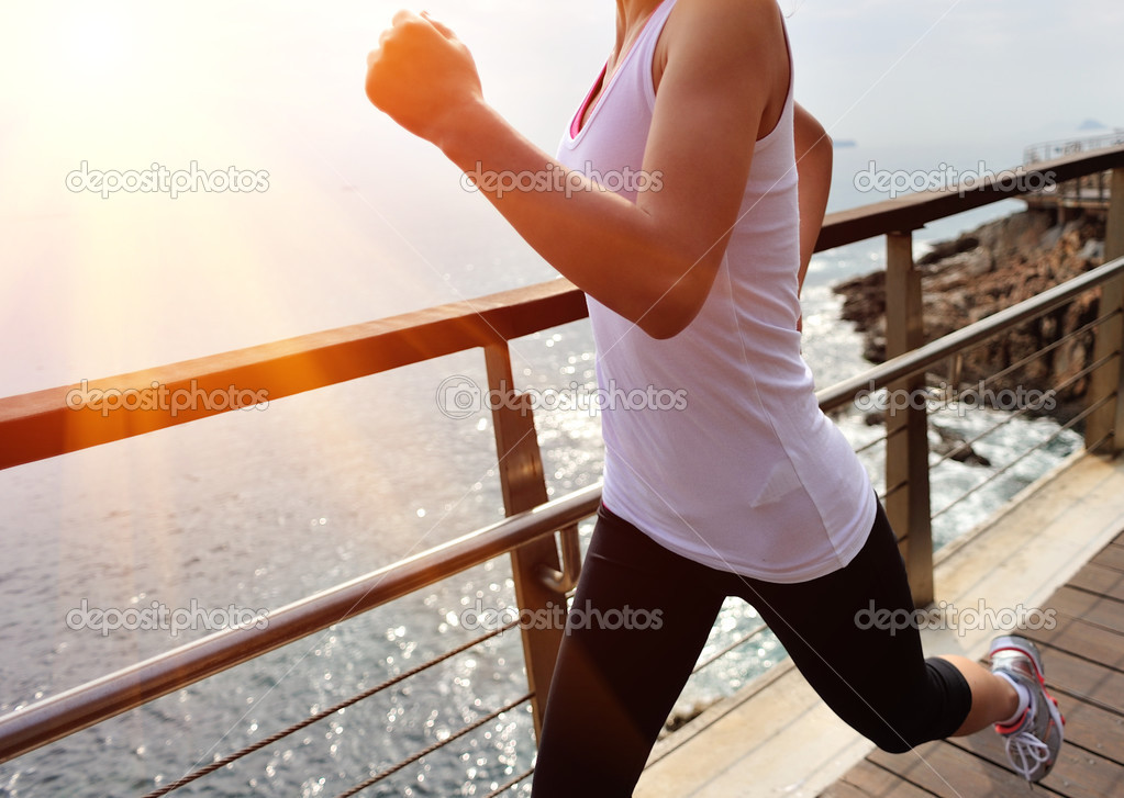 woman running on wooden trail seaside
