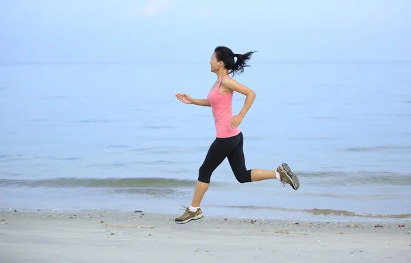 Азиатка бегает по пляжу — стоковое фото