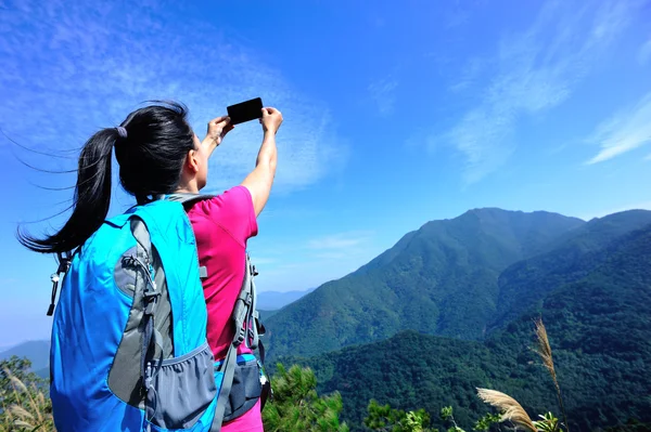 Akıllı telefon ile fotoğraf çekici kadın hiking — Stok fotoğraf