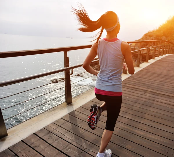 Woman running on wooden trail seaside — Stock Photo, Image
