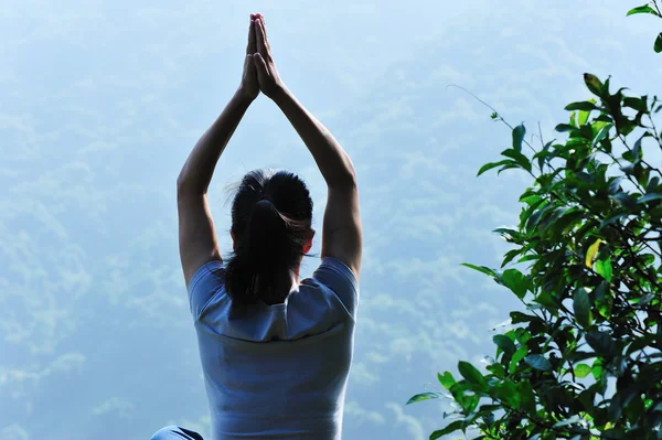 Йога женщина сидит на скале — стоковое фото
