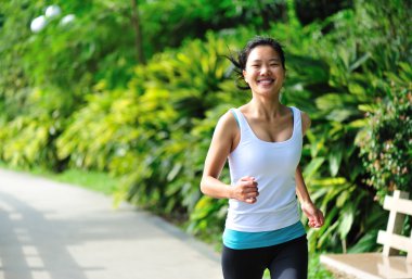 Parkta koşan Asyalı kadın.