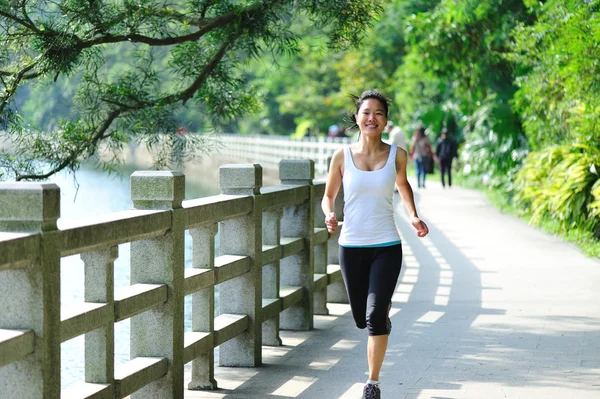 Asiatisk kvinna joggar i parken — Stockfoto
