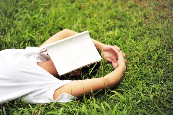 Student leesboek op gras — Stockfoto