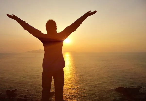 Kvinna öppna armar till soluppgång till sjöss — Stockfoto