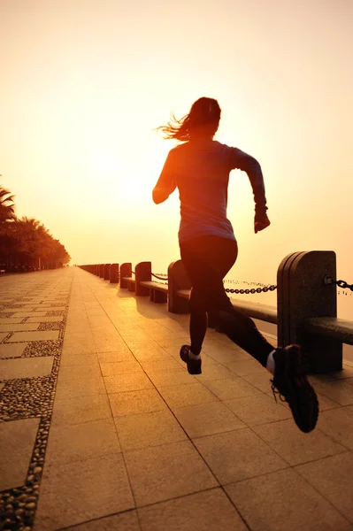 Жінка біжить на узбережжі під ранковим світанком — стокове фото