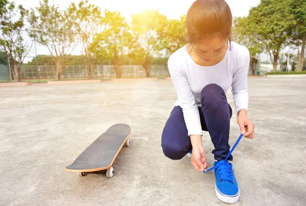 Mladá žena sedí na skateboard — Stock fotografie