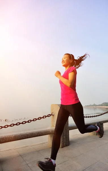 Donna che corre al mare sotto l'alba al mattino — Foto Stock