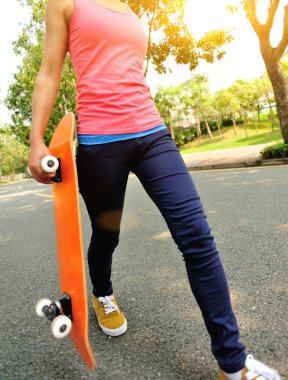 ellerinde kaykay ile yürüyen kadın