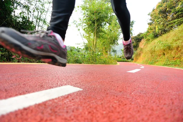 Benen van de vrouw draait op park trail — Stockfoto